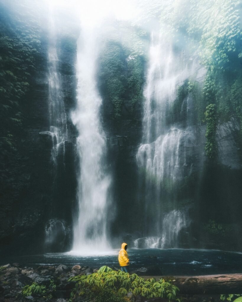 Person in yellow hooded jacket at Fiji Waterfall, Lemukih Village, Buleleng