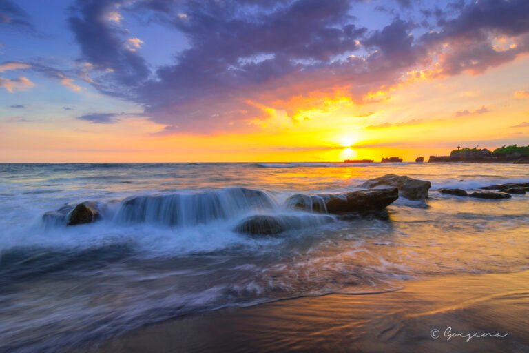 500px provided description: Sunset at Mengening [#sky ,#sunset ,#water ,#beach ,#rock ,#motion ,#bali ,#sand ,#wave ,#cloud]