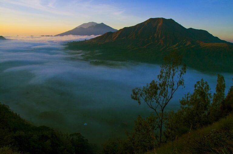 View of Mount Batur from Pinggan village, with morning fog at the foot of the mountain.