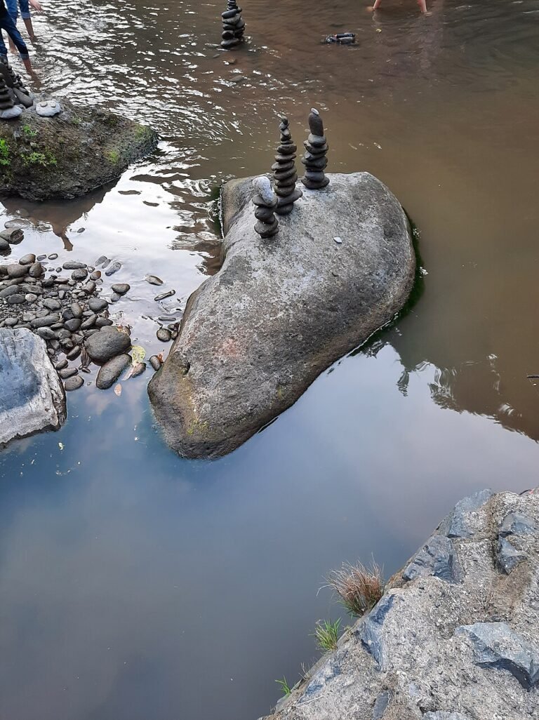 Balanced stones on boulders in the river near the waterfall