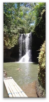 Suwat Waterfall and its pool with a bamboo raft in the foreground.